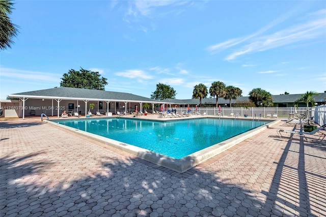 pool featuring fence and a patio area