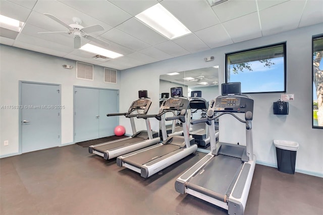 exercise room with baseboards, ceiling fan, a drop ceiling, and visible vents