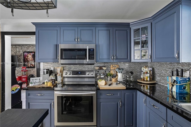 kitchen with blue cabinets, glass insert cabinets, backsplash, and appliances with stainless steel finishes