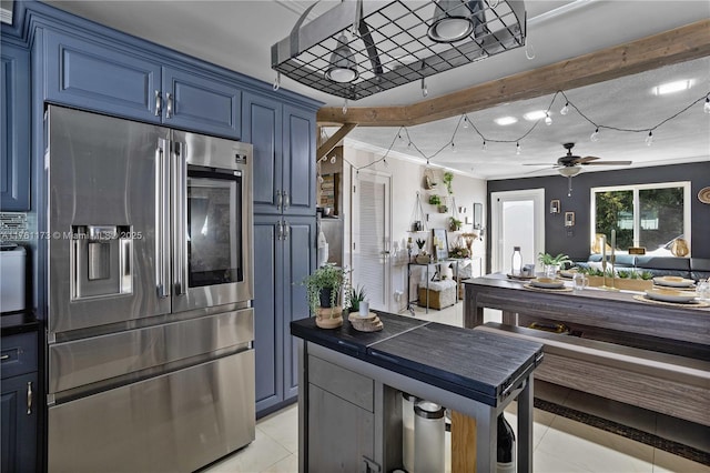 kitchen featuring blue cabinetry, ceiling fan, stainless steel fridge with ice dispenser, and light tile patterned floors