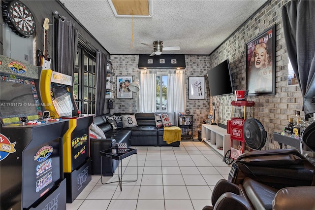 interior space featuring tile patterned floors, brick wall, a textured ceiling, and ceiling fan