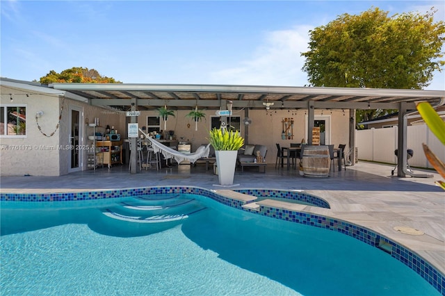 pool with an in ground hot tub, a patio, and fence