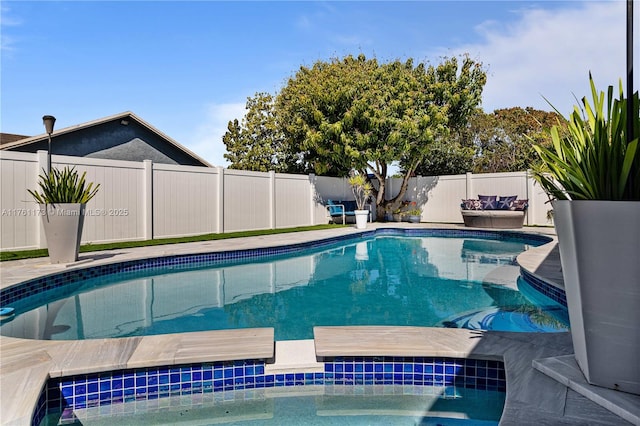 view of swimming pool featuring an in ground hot tub, a fenced in pool, and a fenced backyard