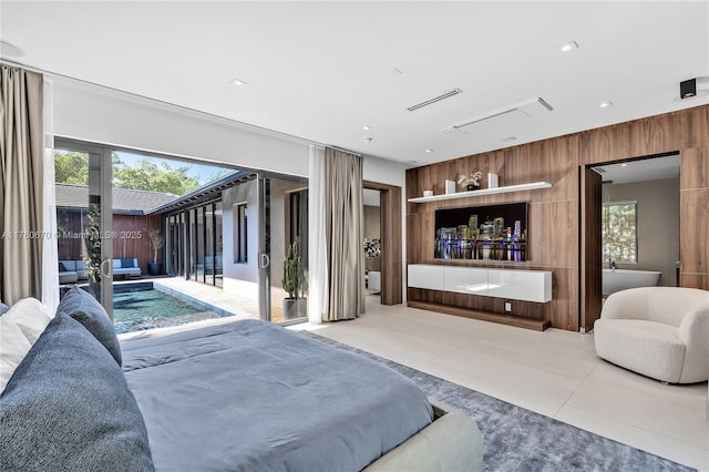 bedroom with wood walls, tile patterned flooring, and access to exterior