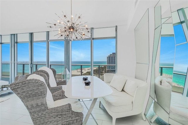 tiled dining area with floor to ceiling windows, a notable chandelier, and a water view