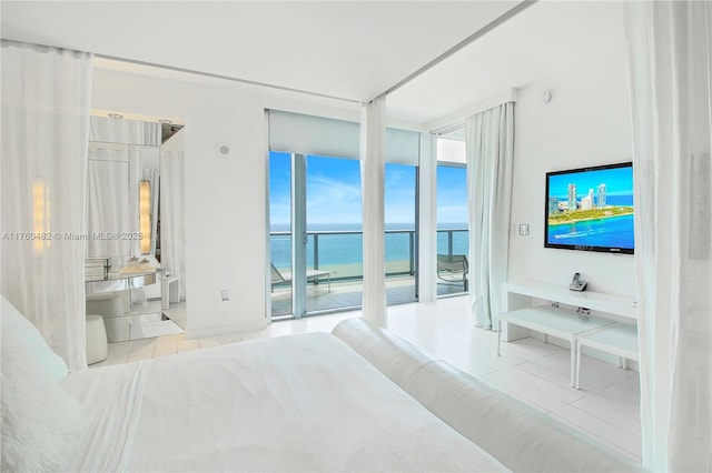 bedroom with tile patterned flooring, ensuite bath, access to outside, and expansive windows