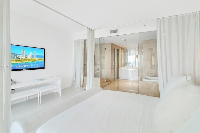 bedroom featuring ensuite bath and visible vents