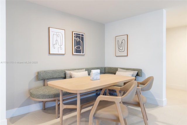 tiled dining area with breakfast area and baseboards