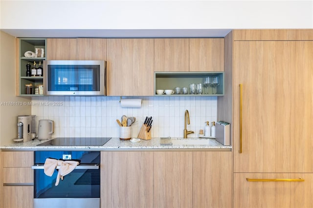 interior space featuring stainless steel microwave, oven, black electric stovetop, modern cabinets, and open shelves