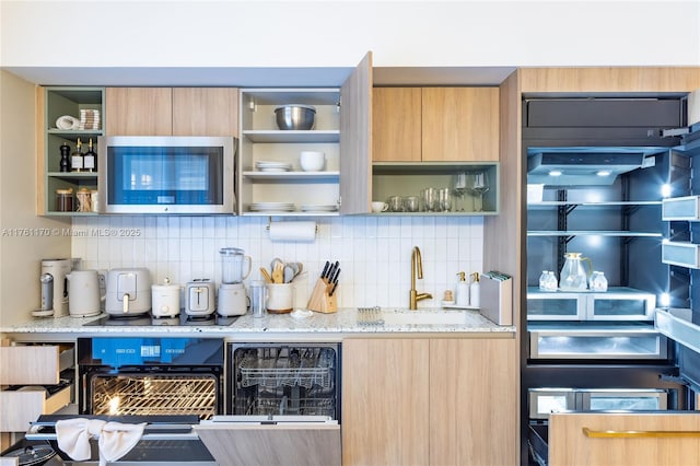 interior space featuring wet bar, stainless steel microwave, backsplash, and a sink