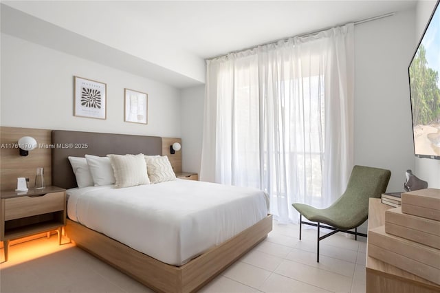 bedroom with light tile patterned floors and multiple windows