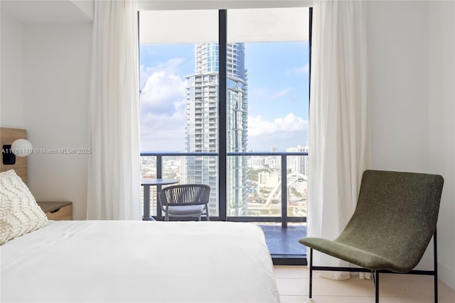 bedroom with tile patterned flooring, access to exterior, a view of city, and expansive windows