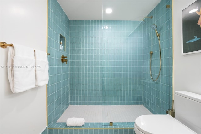 full bath with toilet and tiled shower