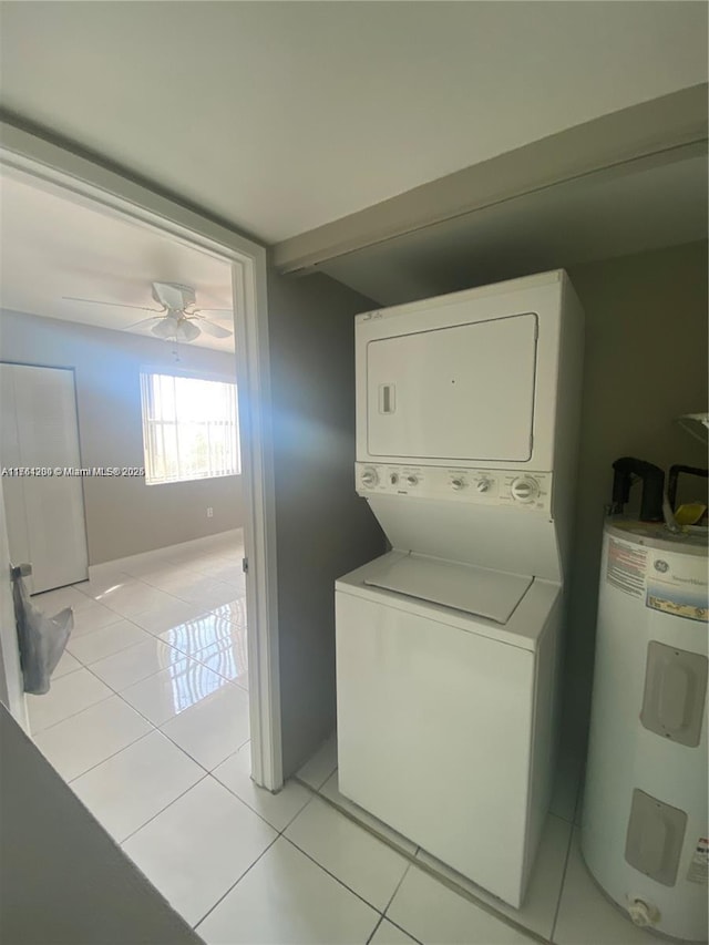 washroom featuring light tile patterned floors, electric water heater, ceiling fan, and stacked washer / dryer