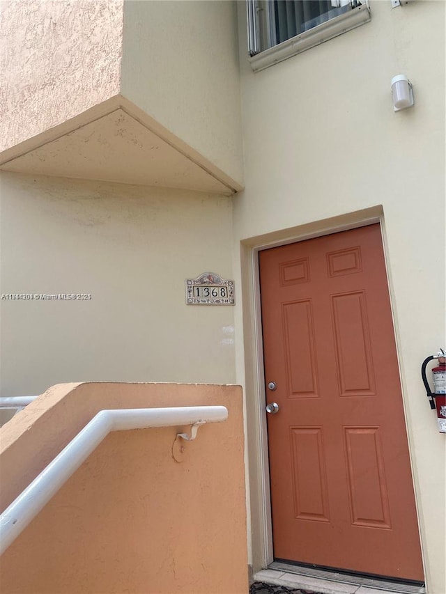 entrance to property featuring stucco siding