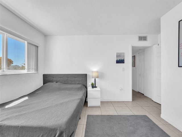 bedroom featuring tile patterned flooring, visible vents, and baseboards