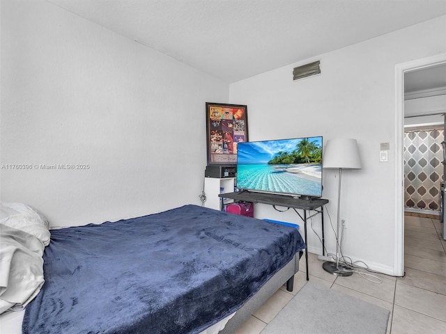 bedroom with tile patterned floors, visible vents, and baseboards