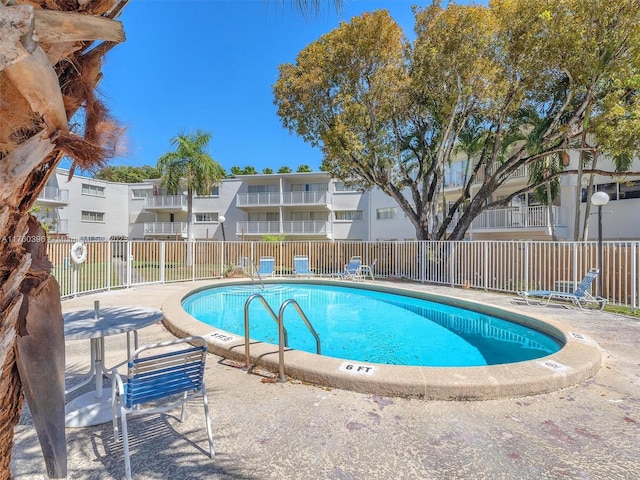 community pool featuring a residential view and fence