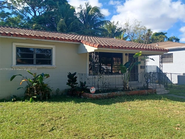 view of front of home with a tiled roof, a porch, and a front yard