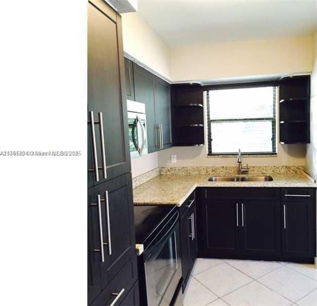 kitchen featuring white microwave, a sink, light tile patterned floors, black / electric stove, and open shelves