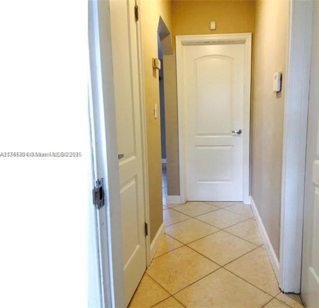 hall with light tile patterned floors and baseboards