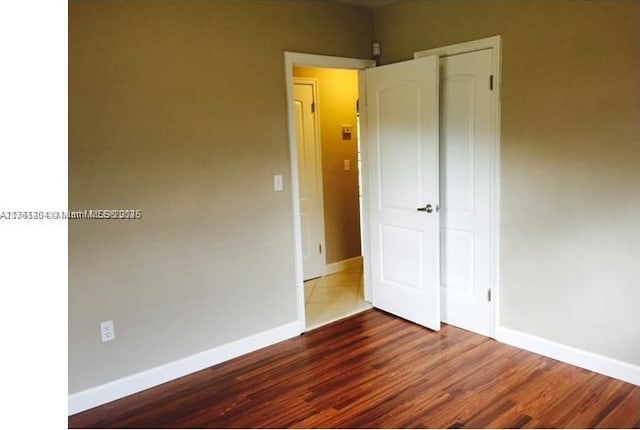 empty room featuring baseboards and wood finished floors