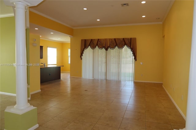 spare room with baseboards, visible vents, ornate columns, and ornamental molding