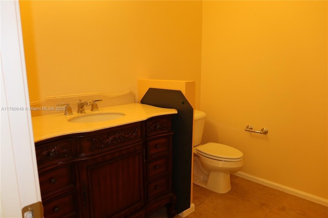 bathroom featuring tile patterned flooring, toilet, vanity, and baseboards