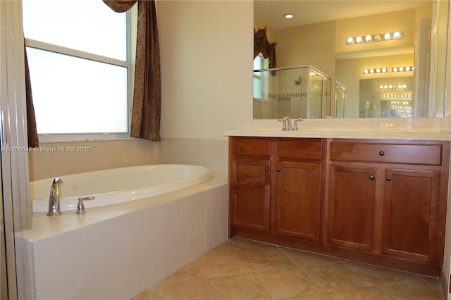 bathroom with a stall shower, a bath, vanity, and tile patterned floors