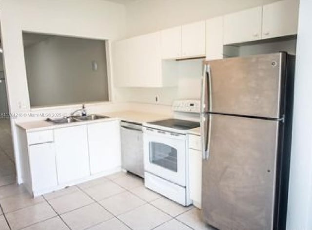 kitchen with a sink, appliances with stainless steel finishes, white cabinets, light tile patterned flooring, and light countertops