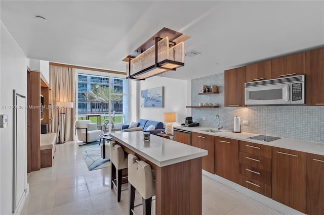 kitchen with tasteful backsplash, stainless steel microwave, visible vents, modern cabinets, and open shelves