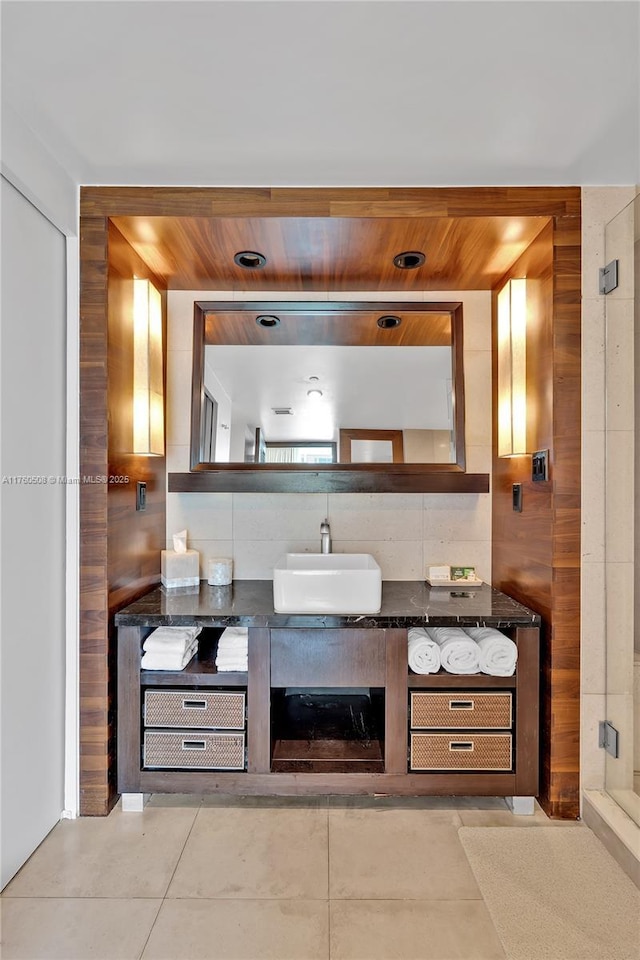 bar featuring tile patterned floors, backsplash, wooden ceiling, and a sink