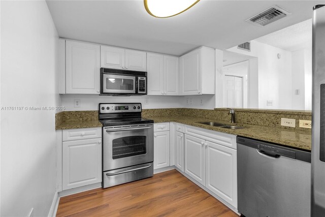 520 SE 5th Ave Unit 1507, Fort Lauderdale, FL 33301 - kitchen featuring stainless steel appliances, white cabinets, light wood-style flooring, and dark stone counters