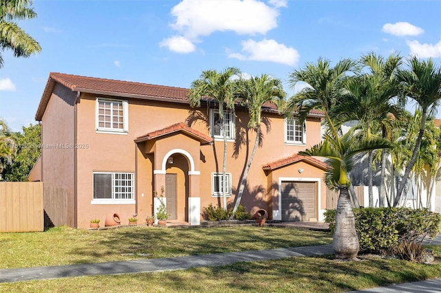 mediterranean / spanish house with stucco siding, a tiled roof, a front yard, and fence