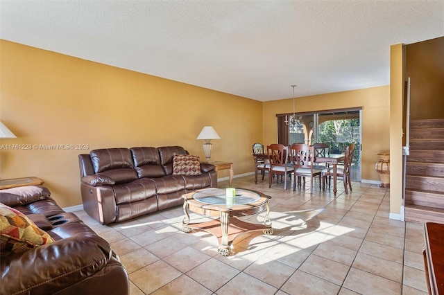 living room featuring baseboards, a notable chandelier, light tile patterned floors, and stairway