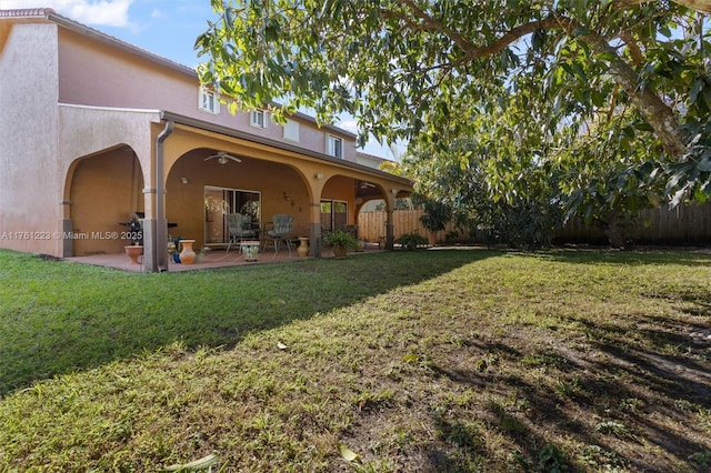 back of house with fence, a patio, stucco siding, and a yard