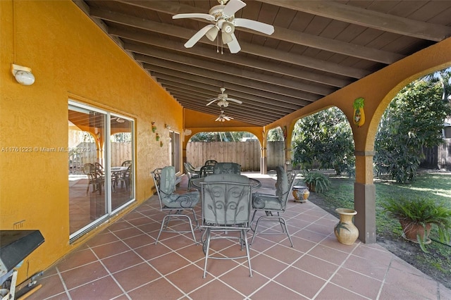 view of patio featuring a ceiling fan, outdoor dining area, and fence