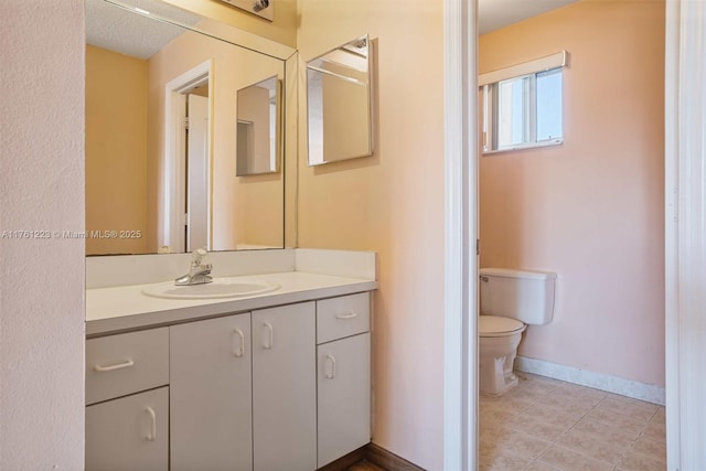 bathroom with tile patterned floors, baseboards, toilet, and vanity