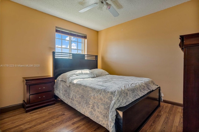 bedroom featuring ceiling fan, baseboards, a textured ceiling, and wood finished floors