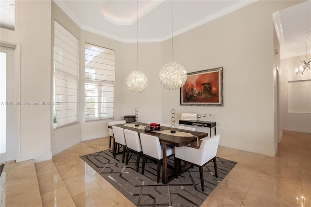 dining space featuring an inviting chandelier, a raised ceiling, baseboards, and ornamental molding