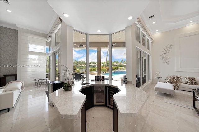 living area featuring floor to ceiling windows, recessed lighting, visible vents, and a towering ceiling