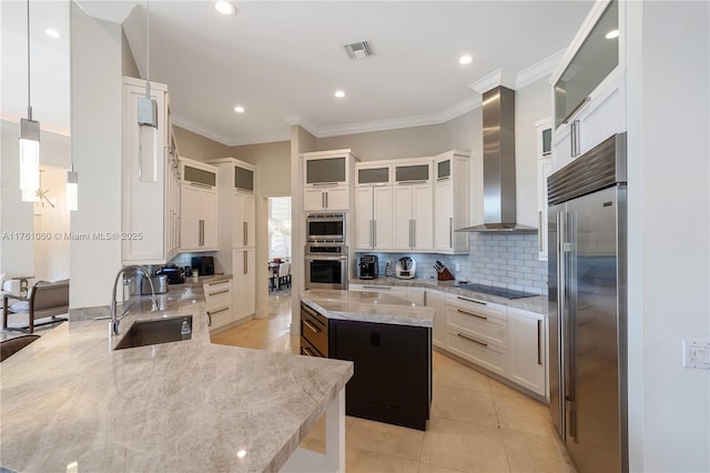 kitchen with backsplash, wall chimney range hood, built in appliances, light tile patterned floors, and a sink