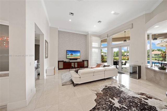 living area with visible vents, an accent wall, ornamental molding, french doors, and marble finish floor