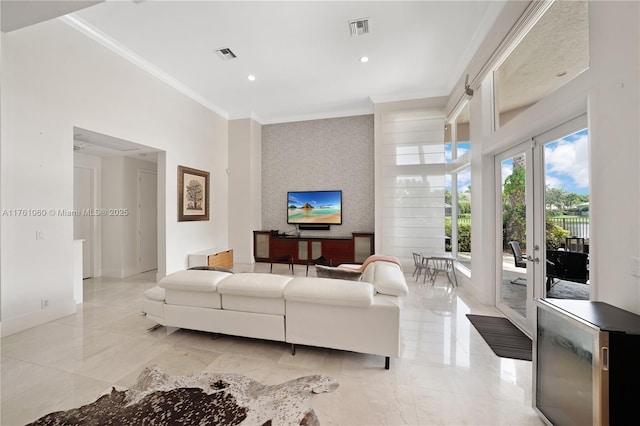 living area featuring visible vents, crown molding, wallpapered walls, and an accent wall