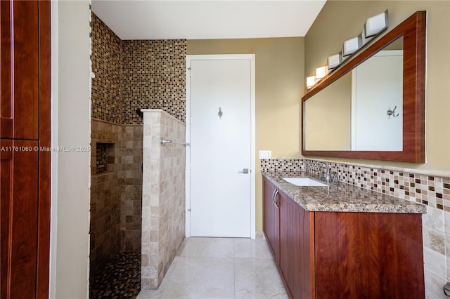 full bath with tile patterned floors, backsplash, a walk in shower, and vanity