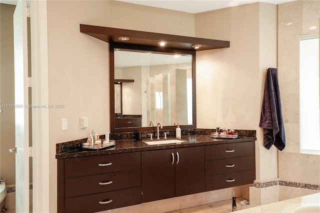 bathroom with walk in shower and vanity