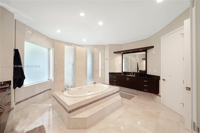 full bath featuring a tub with jets, recessed lighting, and vanity