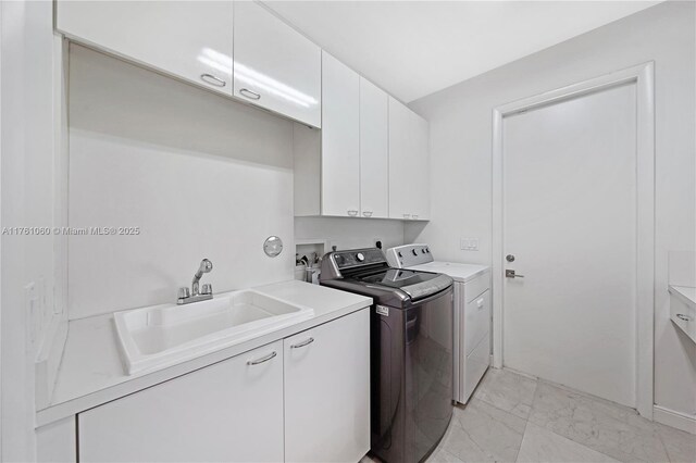 laundry area featuring a sink, cabinet space, marble finish floor, and washing machine and dryer