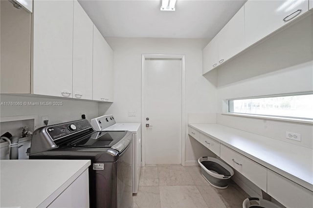 washroom with a sink, cabinet space, marble finish floor, and separate washer and dryer