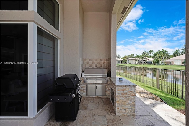 view of patio / terrace featuring a water view, area for grilling, fence, grilling area, and a residential view